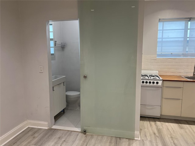 bathroom featuring backsplash, vanity, toilet, and tile flooring