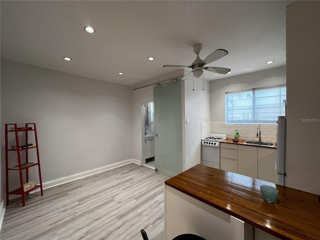 interior space featuring sink, light hardwood / wood-style flooring, and ceiling fan