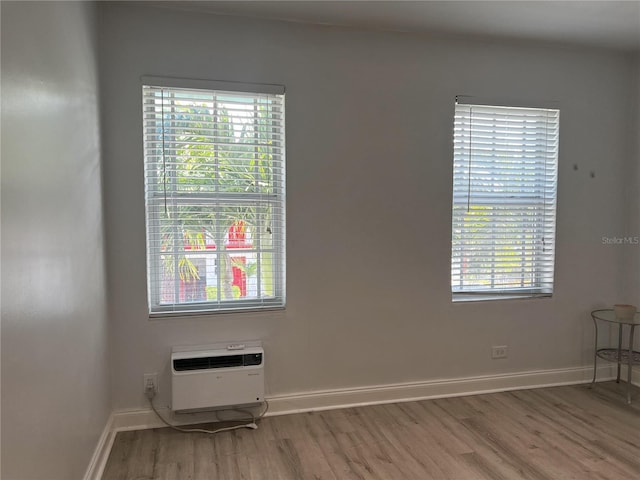 spare room featuring plenty of natural light and hardwood / wood-style floors