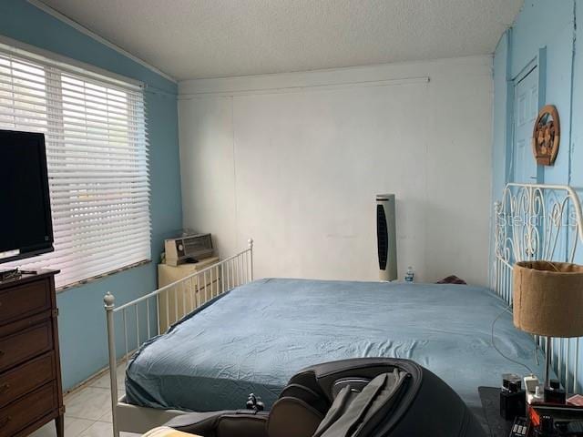 bedroom featuring a textured ceiling and light tile floors