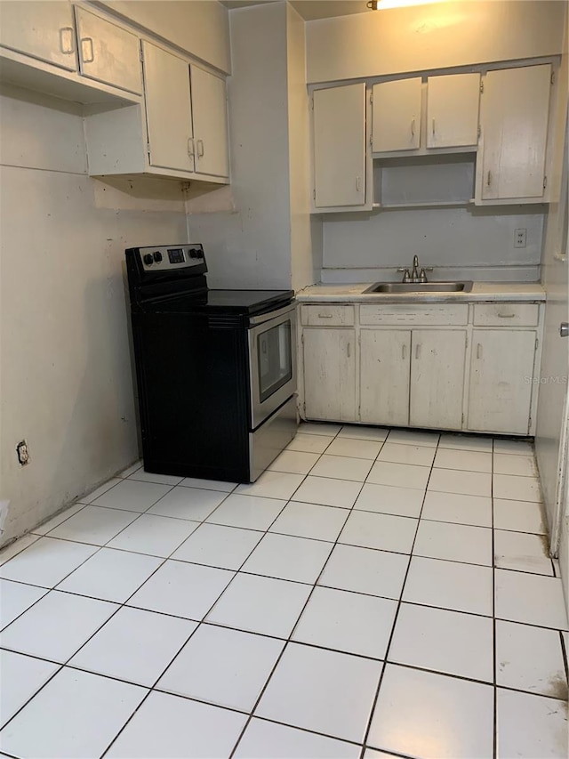 kitchen featuring sink, stainless steel electric stove, and light tile floors