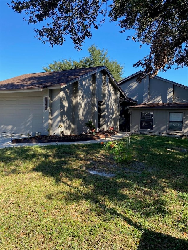 view of front of house with a garage and a front lawn