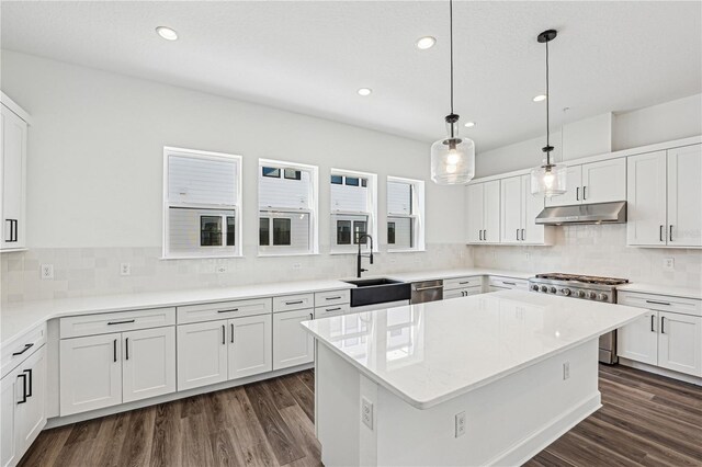 kitchen featuring white cabinetry, pendant lighting, a center island, and sink