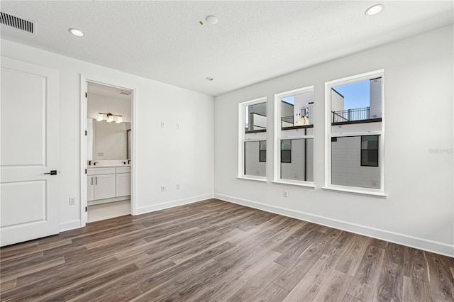 unfurnished room featuring dark wood-type flooring and a textured ceiling