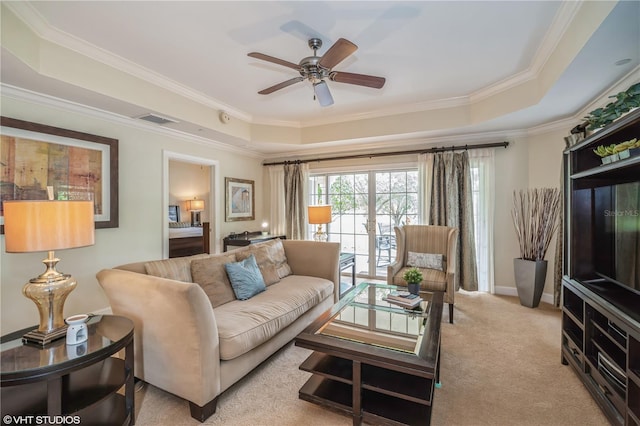 carpeted living room featuring ceiling fan, crown molding, and a raised ceiling