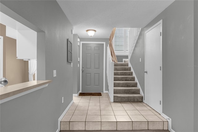 tiled foyer entrance with a textured ceiling