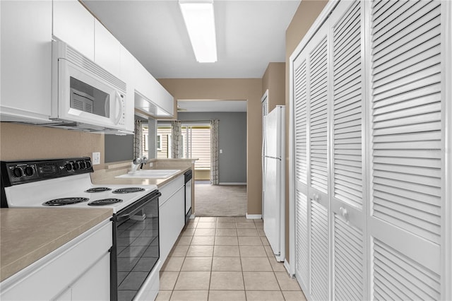 kitchen with light tile patterned flooring, white appliances, a sink, white cabinets, and light countertops