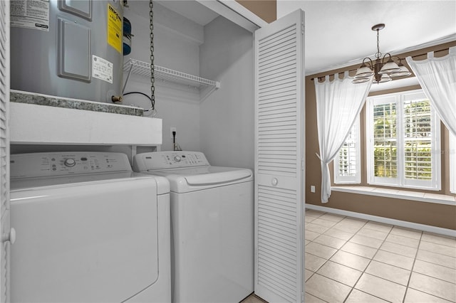 clothes washing area featuring water heater, an inviting chandelier, light tile flooring, and washing machine and clothes dryer