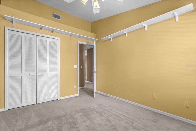 unfurnished bedroom featuring baseboards, visible vents, ceiling fan, carpet, and a closet