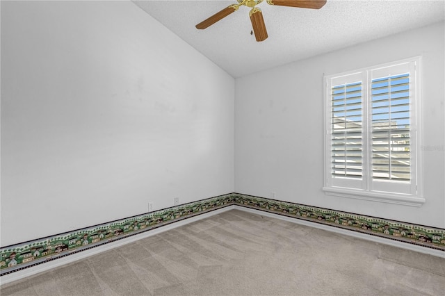 spare room with a textured ceiling, carpet floors, ceiling fan, and vaulted ceiling