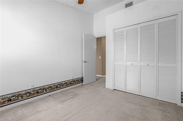 unfurnished bedroom with ceiling fan, visible vents, a closet, and light colored carpet