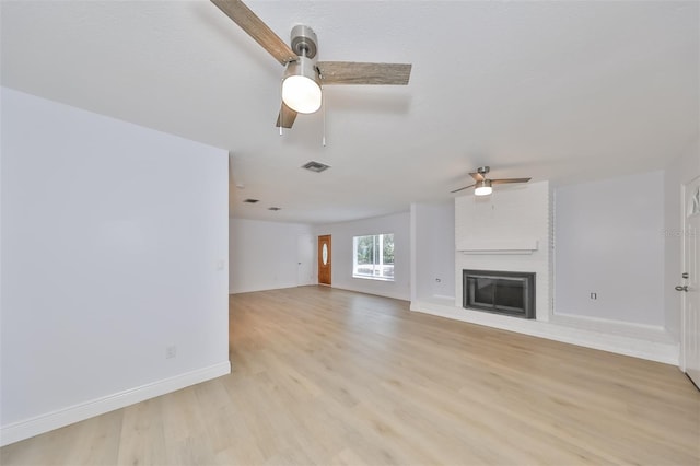 unfurnished living room with a fireplace, ceiling fan, and light hardwood / wood-style floors