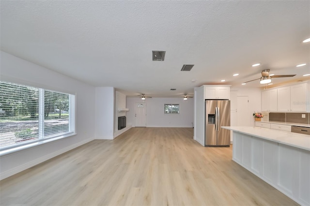 kitchen with white cabinetry, light hardwood / wood-style flooring, stainless steel appliances, and ceiling fan