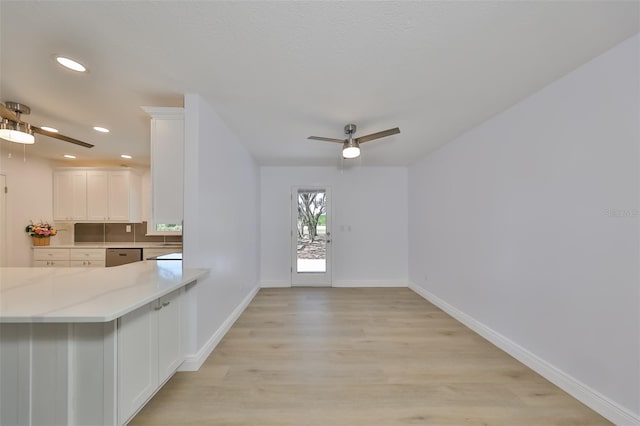 kitchen featuring ceiling fan, white cabinets, backsplash, light wood-type flooring, and stainless steel dishwasher