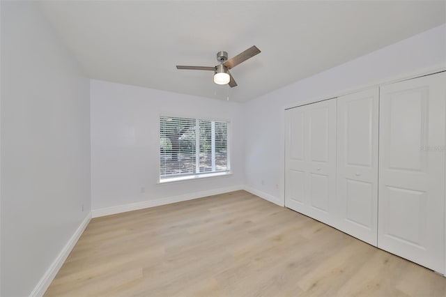 unfurnished bedroom with a closet, light hardwood / wood-style flooring, and ceiling fan