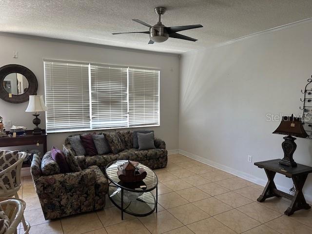 tiled living room featuring a textured ceiling and ceiling fan