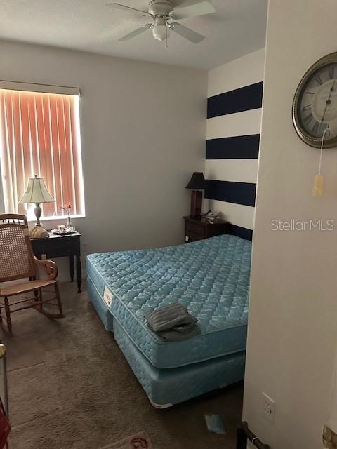 bedroom featuring dark colored carpet and ceiling fan