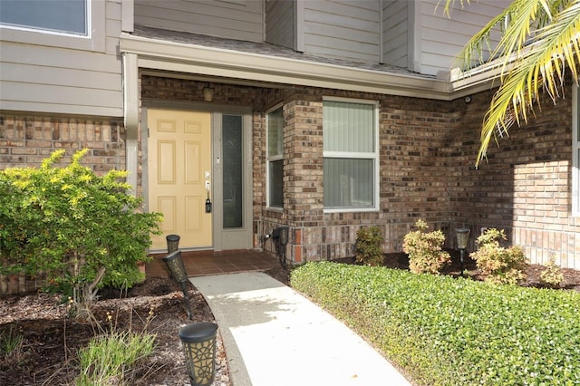 entrance to property featuring brick siding