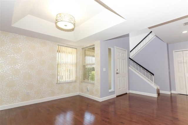 entryway with a tray ceiling and dark hardwood / wood-style floors