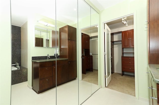 bathroom with tile patterned floors, vanity, and a bath