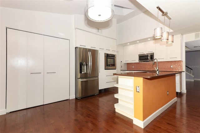 kitchen featuring pendant lighting, white cabinetry, stainless steel appliances, and dark wood-type flooring