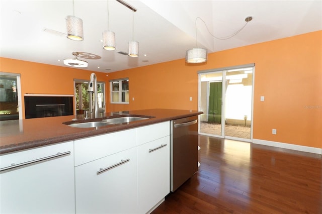 kitchen featuring a healthy amount of sunlight, dark hardwood / wood-style flooring, white cabinetry, and stainless steel dishwasher