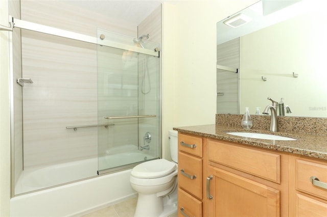 full bathroom with tile patterned floors, vanity, bath / shower combo with glass door, and toilet