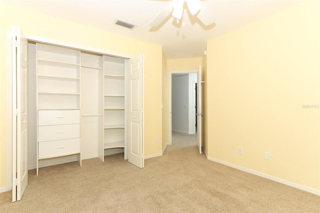 unfurnished bedroom featuring ceiling fan, light carpet, and a closet