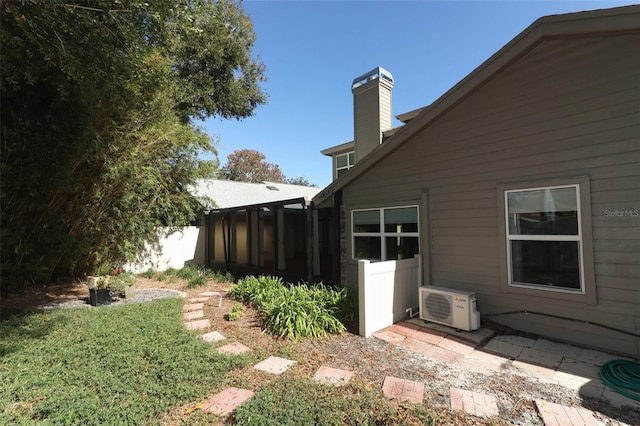 view of yard featuring a sunroom and ac unit