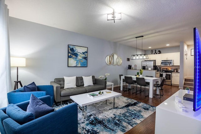 living room featuring dark hardwood / wood-style floors and a textured ceiling