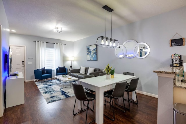 dining area featuring dark hardwood / wood-style floors and a textured ceiling