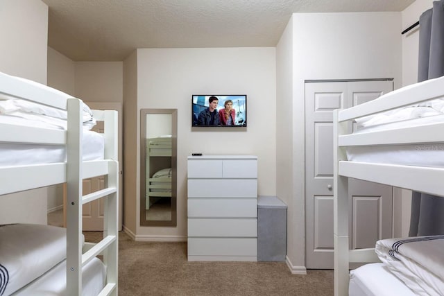 bedroom featuring a textured ceiling and light carpet