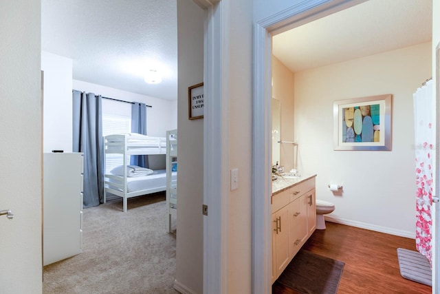 bathroom with wood-type flooring, vanity, and toilet