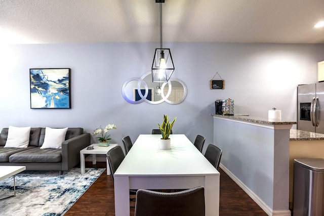 dining space featuring dark hardwood / wood-style floors and a textured ceiling