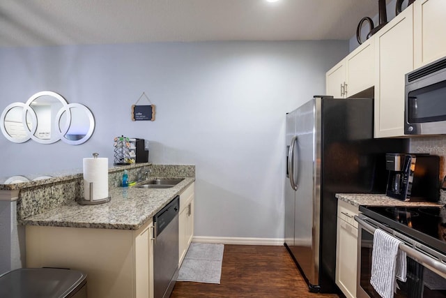 kitchen featuring light stone countertops, appliances with stainless steel finishes, white cabinets, sink, and dark hardwood / wood-style flooring