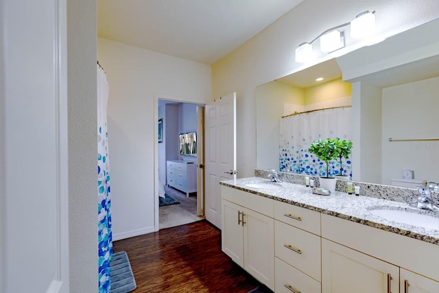 bathroom with hardwood / wood-style flooring and double sink vanity