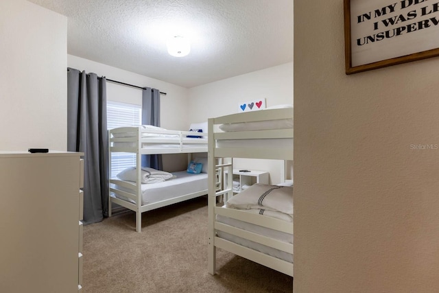 bedroom featuring light carpet and a textured ceiling