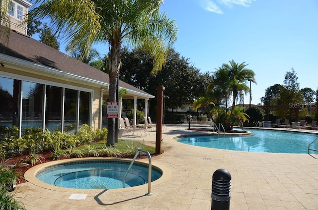 view of pool featuring a hot tub and a patio area