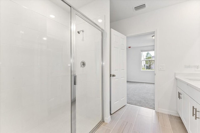 bathroom featuring vanity and a shower with door