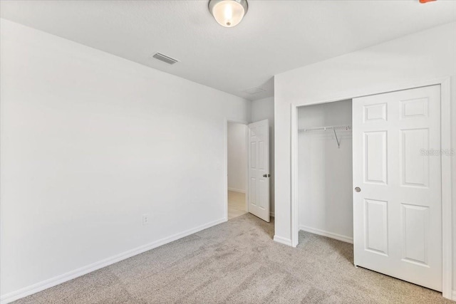 unfurnished bedroom with a closet and light carpet