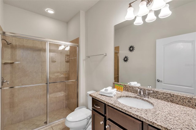 bathroom with a shower with door, vanity, and toilet