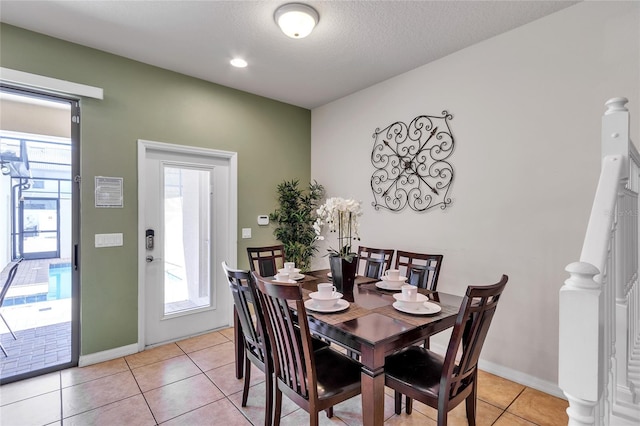 tiled dining room featuring a textured ceiling