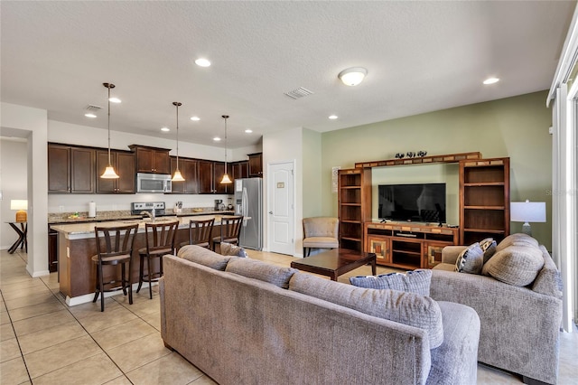 tiled living room featuring a textured ceiling