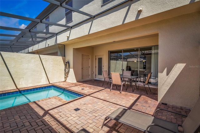 view of swimming pool featuring a patio and glass enclosure