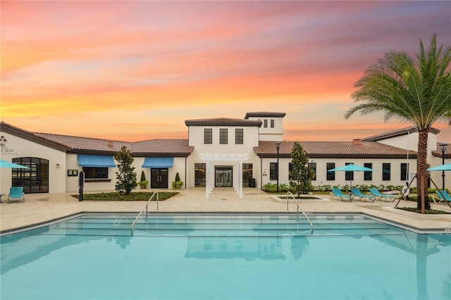 pool at dusk featuring a patio area