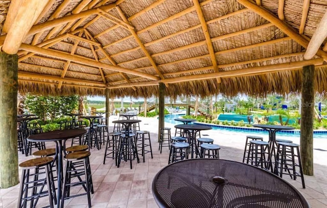 view of terrace with a community pool and a gazebo