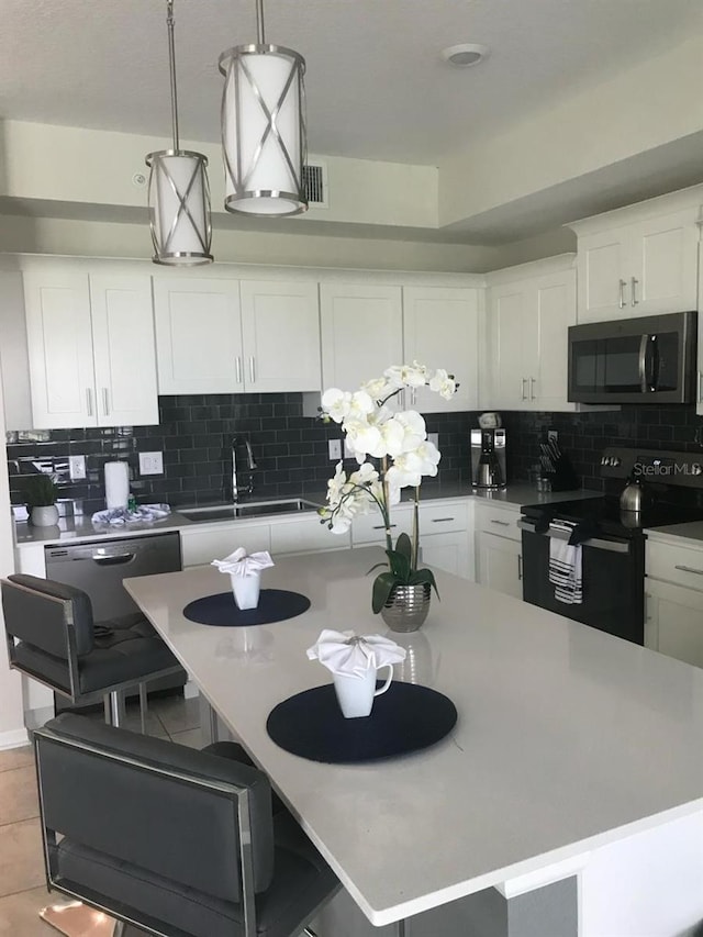 kitchen featuring sink, electric stove, backsplash, and white cabinetry