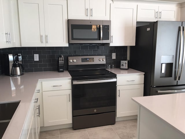 kitchen featuring white cabinets, appliances with stainless steel finishes, and tasteful backsplash