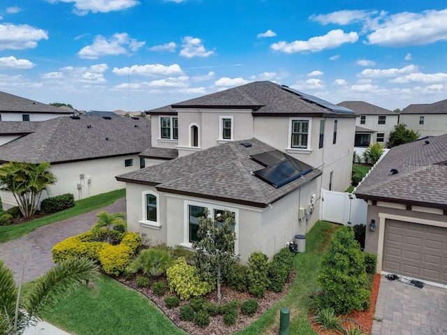 view of front of property featuring solar panels, a garage, and central air condition unit