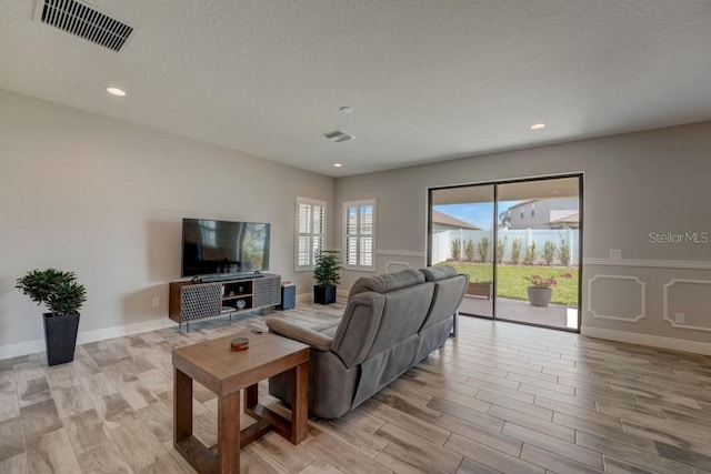 living room with light hardwood / wood-style floors and a textured ceiling